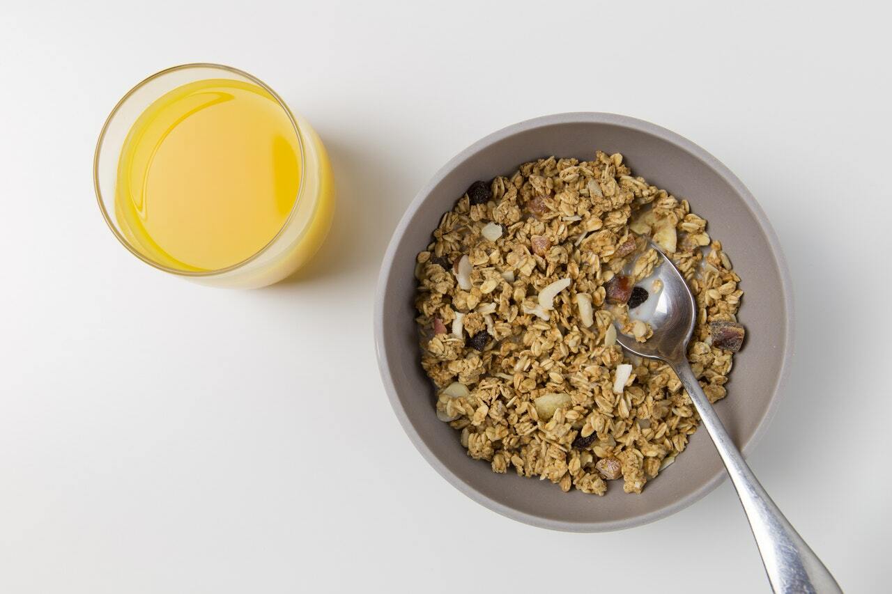 bowl of oats and mixed nuts and glass of juice